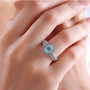 paraiba tourmaline and diamond halo ring in 950 platinum worn on a hand