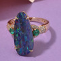 boulder opal triplet colombian emerald and diamond ring in 14k yellow gold shown in a lifestyle photo