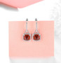 close up of sugar-loaf cut hessonite garnet dangle earrings in rhodium over sterling silver