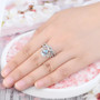 sky blue topaz and white zircon crown ring in rhodium over sterling silver worn on a hand