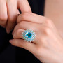 blue and green quartz triplet peridot apatite and zircon halo ring in rhodium over sterling silver worn on a hand