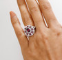 rhodolite garnet and moissanite halo ring in rhodium over sterling silver worn on a hand