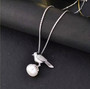 freshwater pearl and moissanite bird pendant necklace in rhodium over sterling silver shown in a lifestyle photo