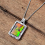 ammolite and white zircon halo pendant necklace in rhodium over sterling silver shown in a lifestyle photo
