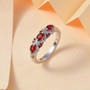 reddish orange sapphire and moissanite band ring in rhodium over sterling silver shown in a lifestyle photo