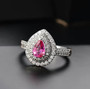 padparadscha sapphire and diamond halo ring in 950 platinum shown in a lifestyle photo