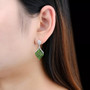 chrome diopside and white zircon dangle earrings in rhodium over sterling silver worn on the ear