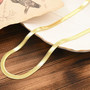 6mm herringbone chain necklace in 18k yellow gold over sterling silver shown in a lifestyle photo