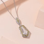 moissanite and yellow sapphire shield cut halo pendant necklace in rhodium over sterling silver shown in a lifestyle photo