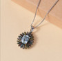 aquamarine and multi color diamond flower blossom halo pendant necklace in rhodium over sterling silver shown in a lifestyle photo