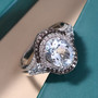 aquamarine champagne and white diamond double halo ring in rhodium over sterling silver shown in a lifestyle photo