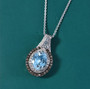 aquamarine champagne and white diamond double halo pendant necklace in rhodium over sterling silver shown in a lifestyle photo