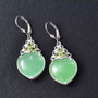 green jade and peridot heart dangle earrings in rhodium over sterling silver shown in a lifestyle photo