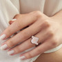 pink and white diamond halo ring in 14k rose gold worn on a hand