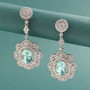 paraiba tourmaline and diamond earrings in 950 platinum shown in a lifestyle photo