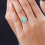 ethiopian opal oval cabochon and diamond solitaire ring in 18k white gold worn on a hand