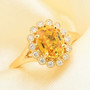 orange sapphire and diamond halo ring in 18k yellow gold shown in a lifestyle photo