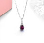 rhodolite garnet 5mm round solitaire necklace in rhodium over sterling silver shown in a lifestyle photo