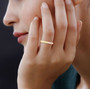 pink diamond and yellow diamond two-tone eternity band ring in 14k rose gold and 14k yellow gold worn on a hand