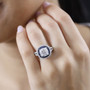 moissanite and blue sapphire double halo rhodium over sterling silver ring worn on a hand