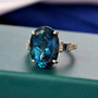 oval london blue topaz blue and white diamond 10k yellow gold ring shown in a lifestyle photo