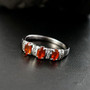 fire opal and white zircon trilogy ring in rhodium over sterling silver shown in a lifestyle photo