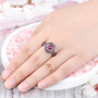 rhodolite garnet and white zircon double halo ring in black and white rhodium over sterling silver worn on a hand