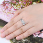 aquamarine and white zircon rhodium over sterling silver trilogy ring worn on a hand