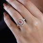 padparadscha sapphire and moissanite triple halo ring in 18k yellow gold over sterling silver worn on a hand
