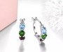 close up of blue topaz chrome diopside and garnet hoop earrings in rhodium over sterling silver