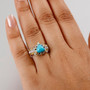 sleeping beauty turquoise and white zircon two-tone 18k yellow gold and rhodium over sterling silver ring worn on a hand
