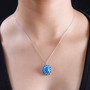 ceruleite and moissanite oval halo pendant necklace in rhodium over sterling silver worn around the neck