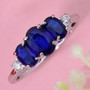 blue spinel trilogy ring and moissanite accents in rhodium over sterling silver shown in a lifestyle photo