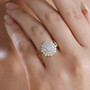 round moissanite cluster ring in 18k yellow gold over sterling silver worn on a hand