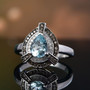 aquamarine champagne and white diamond halo ring in rhodium over sterling silver shown in a lifestyle photo