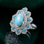 larimar neon apatite and white zircon halo ring in rhodium over sterling silver shown in a lifestyle photo
