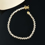 white zircon tapered baguette tennis bracelet in 18k yellow gold over sterling silver shown in a lifestyle photo