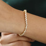 white zircon tapered baguette tennis bracelet in 18k yellow gold over sterling silver worn on a wrist