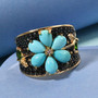 turquoise black spinel chrome diopside and zircon flower ring in 18k yellow gold over sterling silver shown in a lifestyle photo