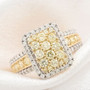 yellow and white diamond cluster halo ring in 14k yellow gold shown in a lifestyle photo