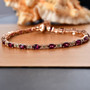 rhodolite garnet tsavorite garnet and moissanite tennis bracelet in 18k rose gold over sterling silver shown in a lifestyle photo