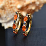 fire opal blue sapphire and moissanite hoop earrings in 18k yellow gold over sterling silver shown in a lifestyle photo