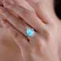 pear ethiopian opal and diamond halo rhodium over sterling silver ring worn on a hand