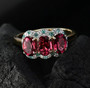 rubellite tourmaline paraiba tourmaline and diamond trilogy ring in 10k yellow gold shown in a lifestyle photo