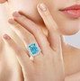 aquamarine and emerald cut diamond halo ring in 950 platinum worn on a hand