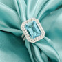 aquamarine and emerald cut diamond halo ring in 950 platinum shown in a lifestyle photo