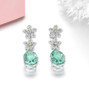 full view of green fluorite peridot and white zircon dangle earrings in rhodium over sterling silver