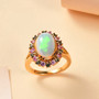 ethiopian opal green and pink sapphire halo ring in 18k yellow gold over sterling silver shown in a lifestyle photo