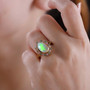 ethiopian opal green and pink sapphire halo ring in 18k yellow gold over sterling silver worn on a hand