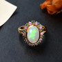 close up of ethiopian opal green and pink sapphire halo ring in 18k yellow gold over sterling silver
